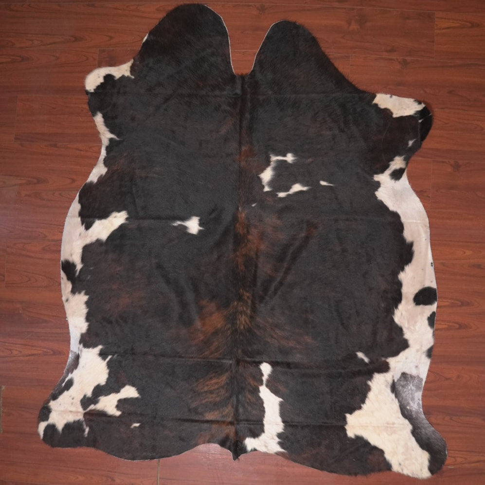 Black and white cowhide rug on a wooden floor