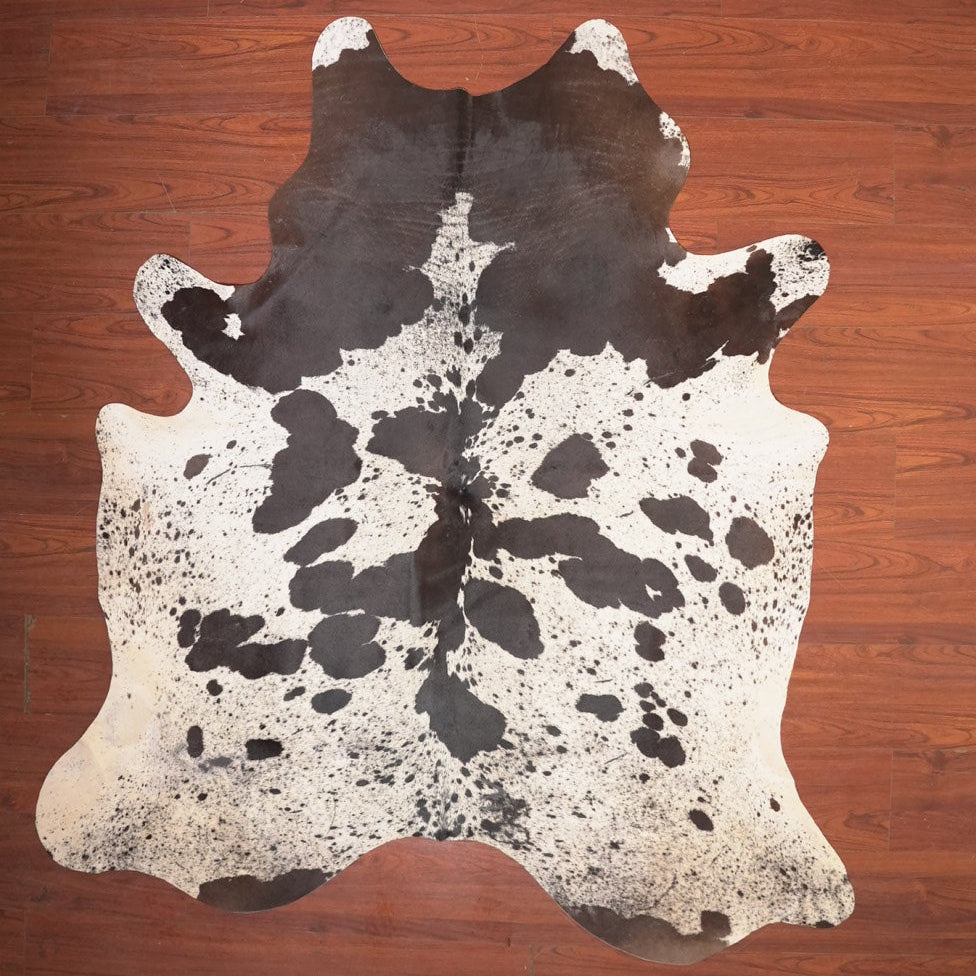 Cowhide rug with black and white pattern on a wooden floor