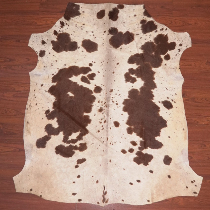 Cowhide rug with brown and white pattern on a wooden floor