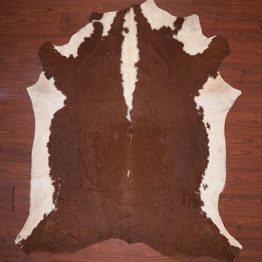 Brown and white cowhide rug on a wooden floor