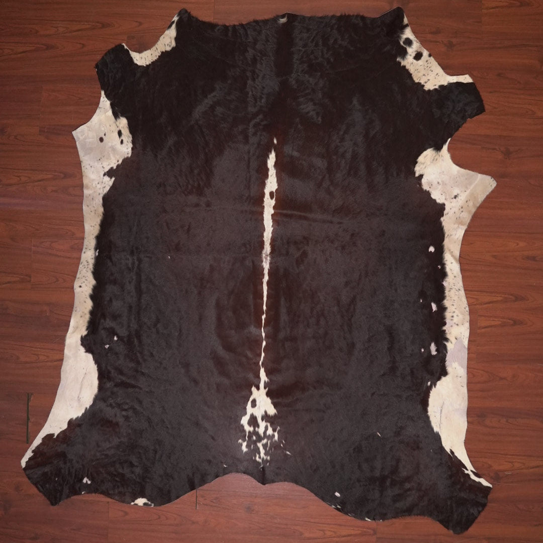 Cowhide rug with black and white pattern on a wooden floor