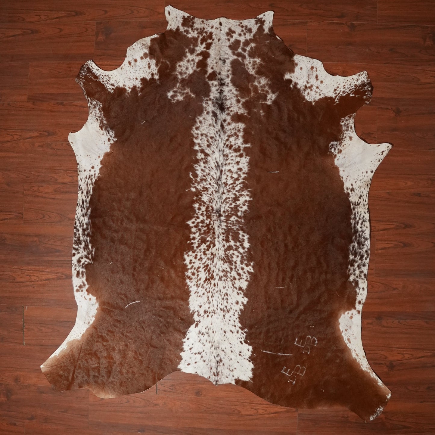 Cowhide rug with brown and white pattern on a wooden floor