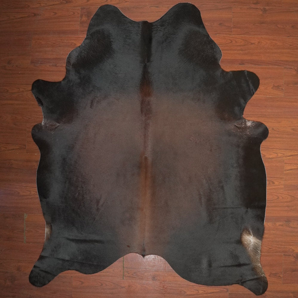 Black cowhide rug on a wooden floor