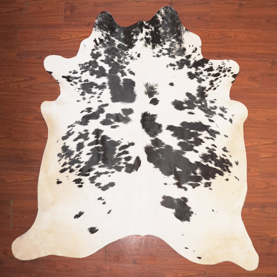 Cowhide rug with black and white pattern on a wooden floor