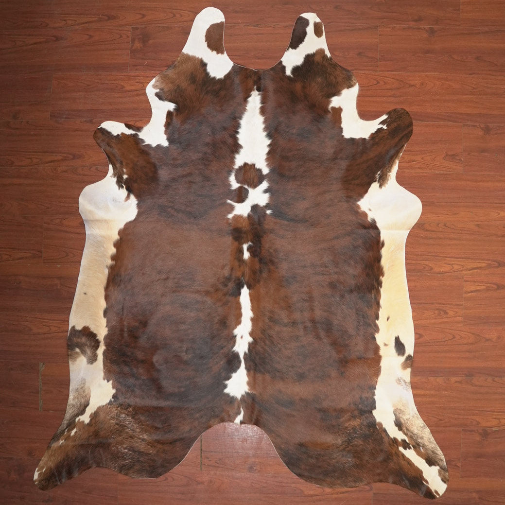 Cowhide rug with brown and white pattern on a wooden floor