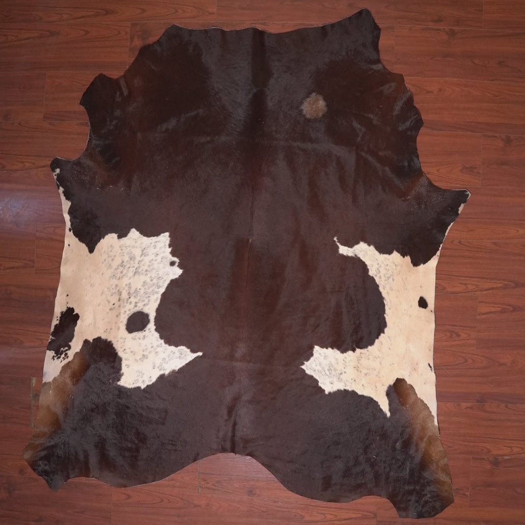 Cowhide rug with black and white pattern on a wooden floor