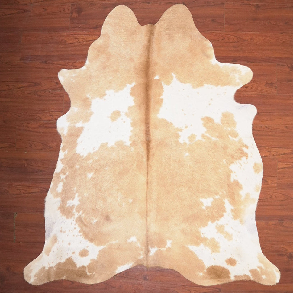 Cowhide rug with brown and white pattern on a wooden floor
