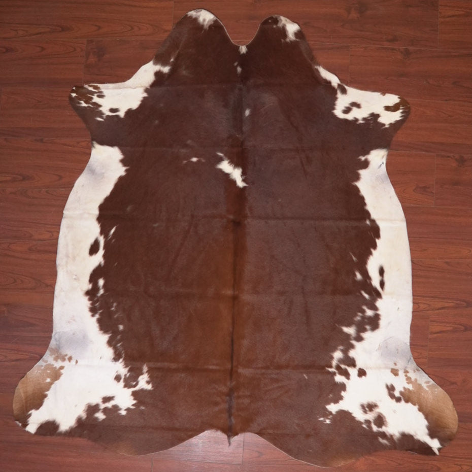 Cowhide rug with brown and white pattern on a wooden floor