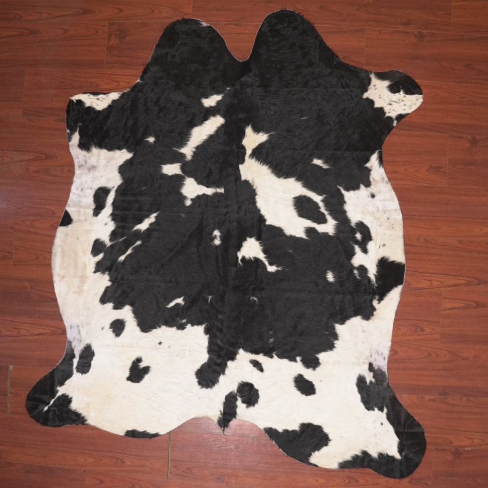 Black and white cow hiude rug on wood floor