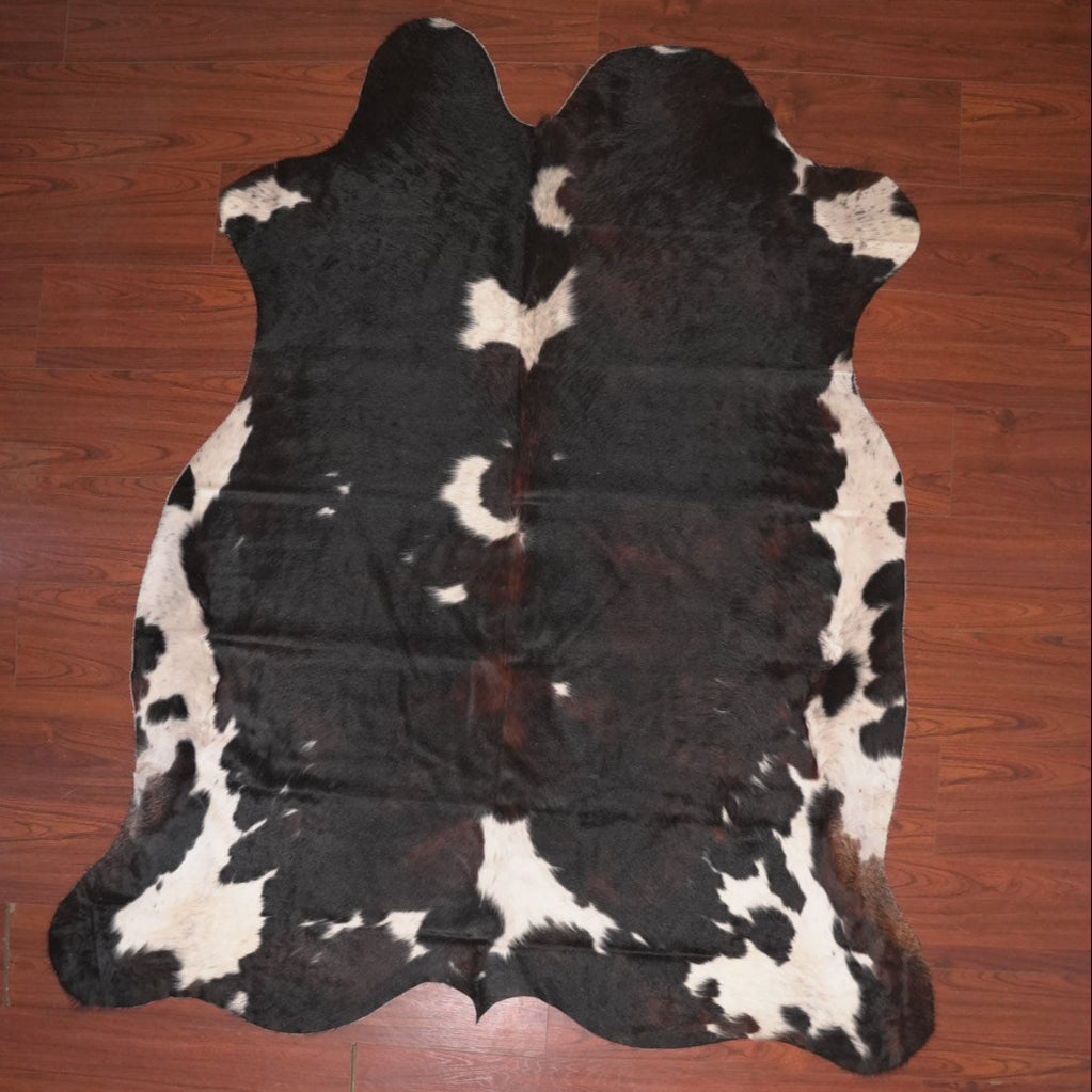 Black and white cowhide rug on a wooden floor