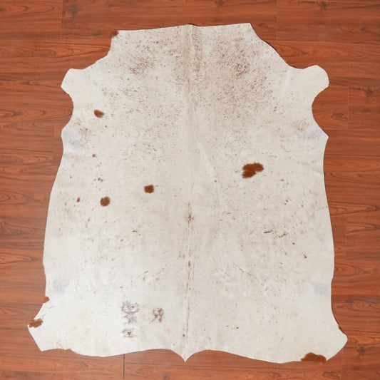White cowhide rug on a wooden floor