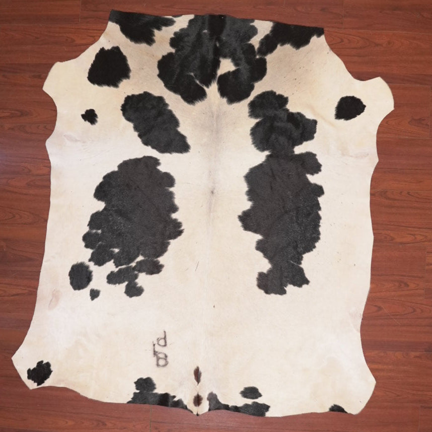 Cowhide rug with black and white pattern on a wooden floor