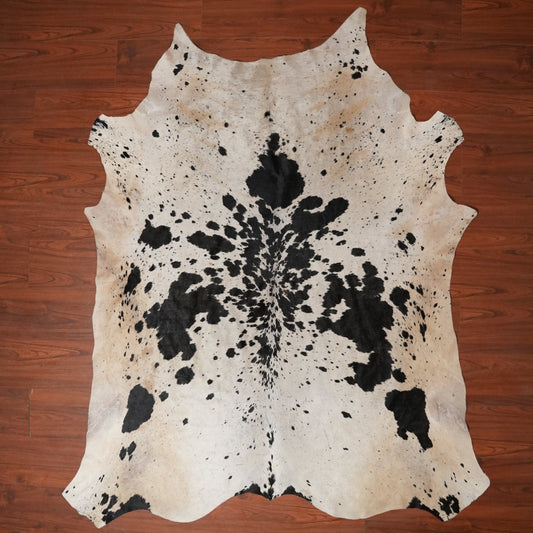 Cowhide rug with black and white pattern on a wooden floor