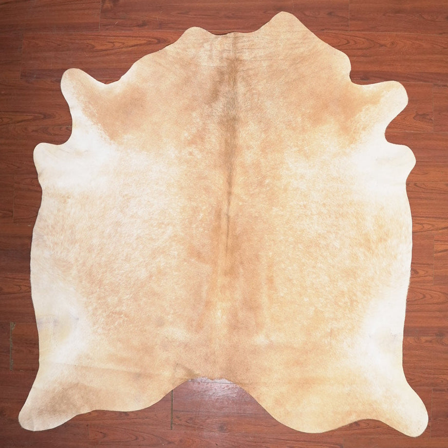 Beige cowhide rug on a wooden floor