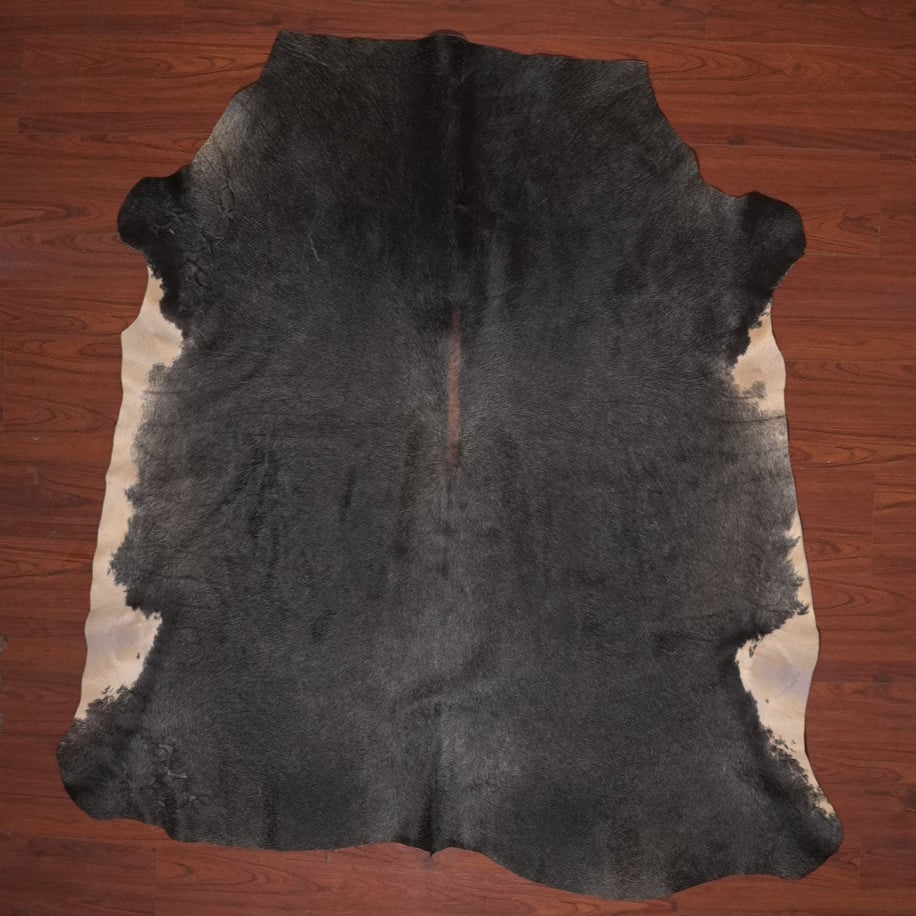 Black cowhide rug on a wooden floor