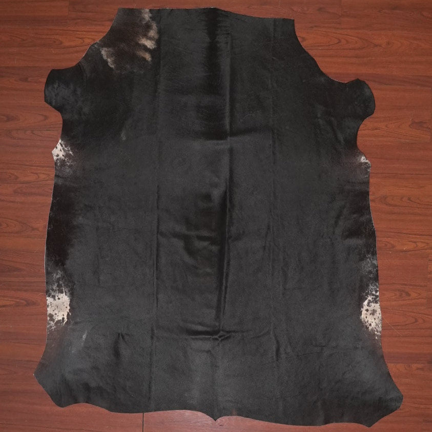 Black cowhide rug on a wooden floor