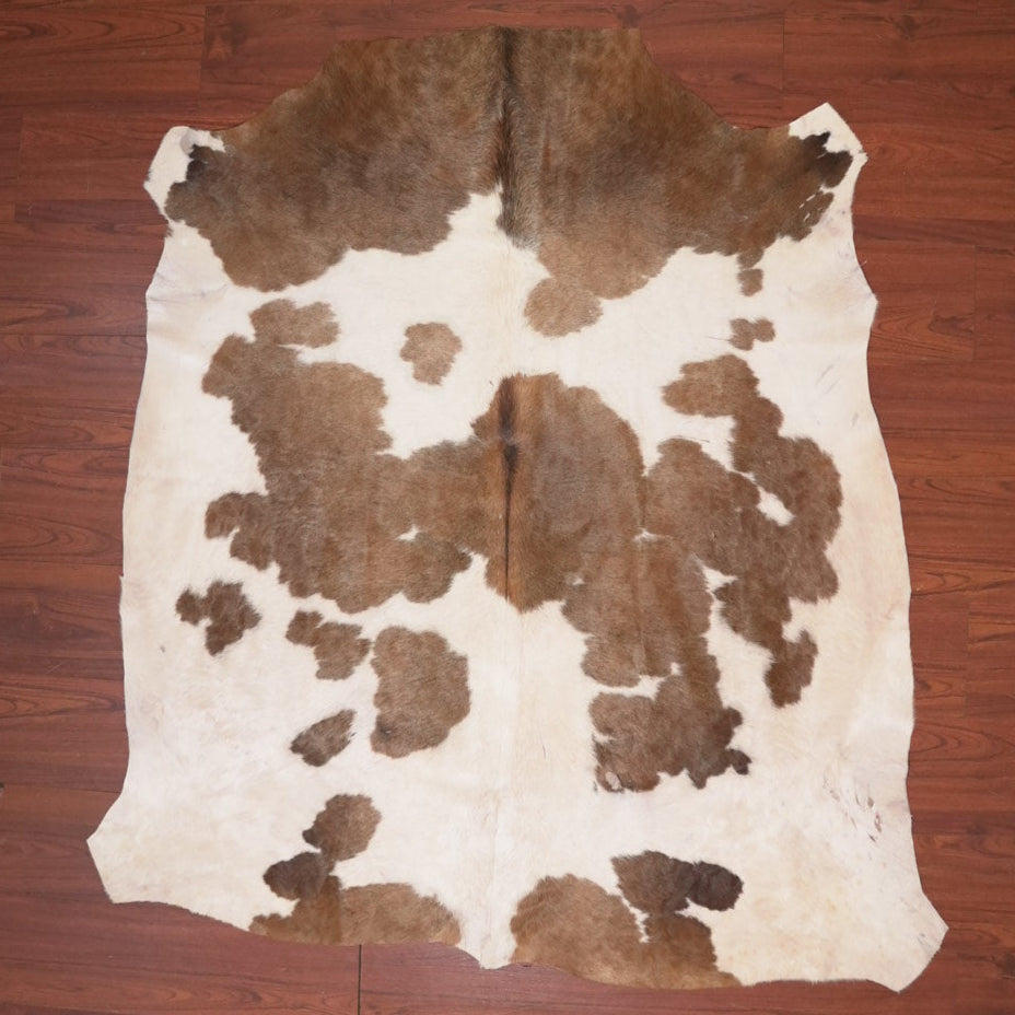 Cowhide rug with brown and white pattern on a wooden floor