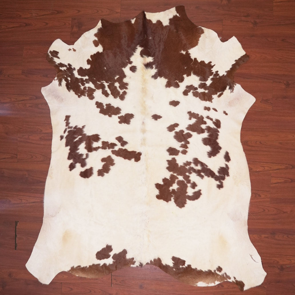 Cowhide rug with brown and white pattern on a wooden floor