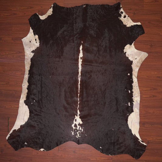 Cowhide rug with black and white pattern on a wooden floor