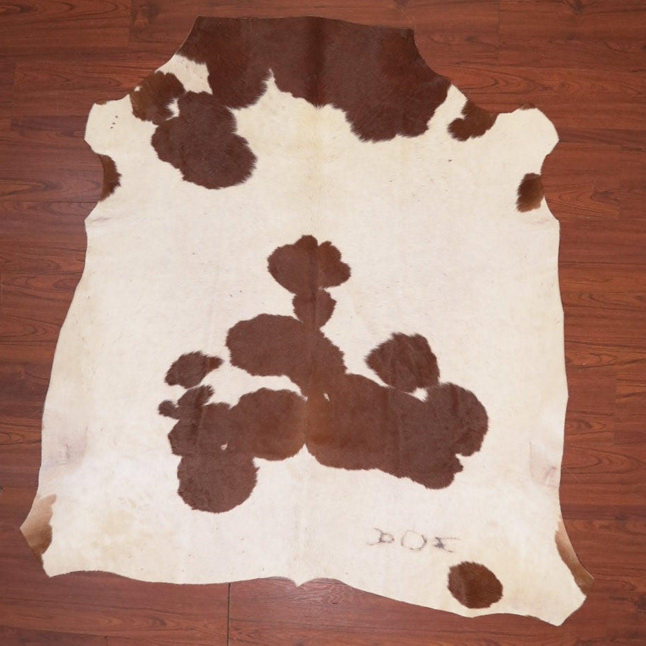 Cowhide rug with brown and white pattern on a wooden floor