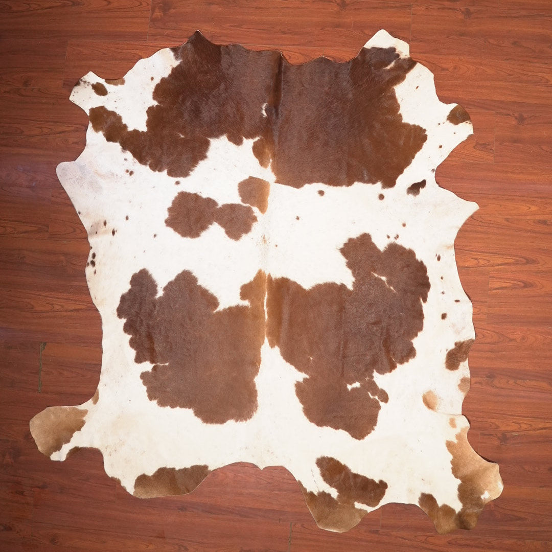 Cowhide rug with brown and white pattern on a wooden floor